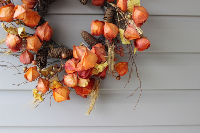 decorating a house for fall with a wreath hanging on vinyl siding